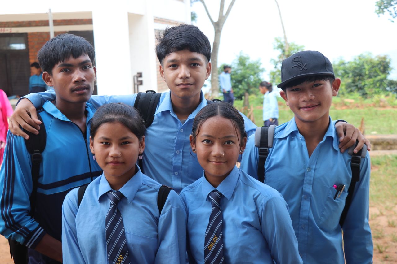 Students in uniform standing together with arms around each other